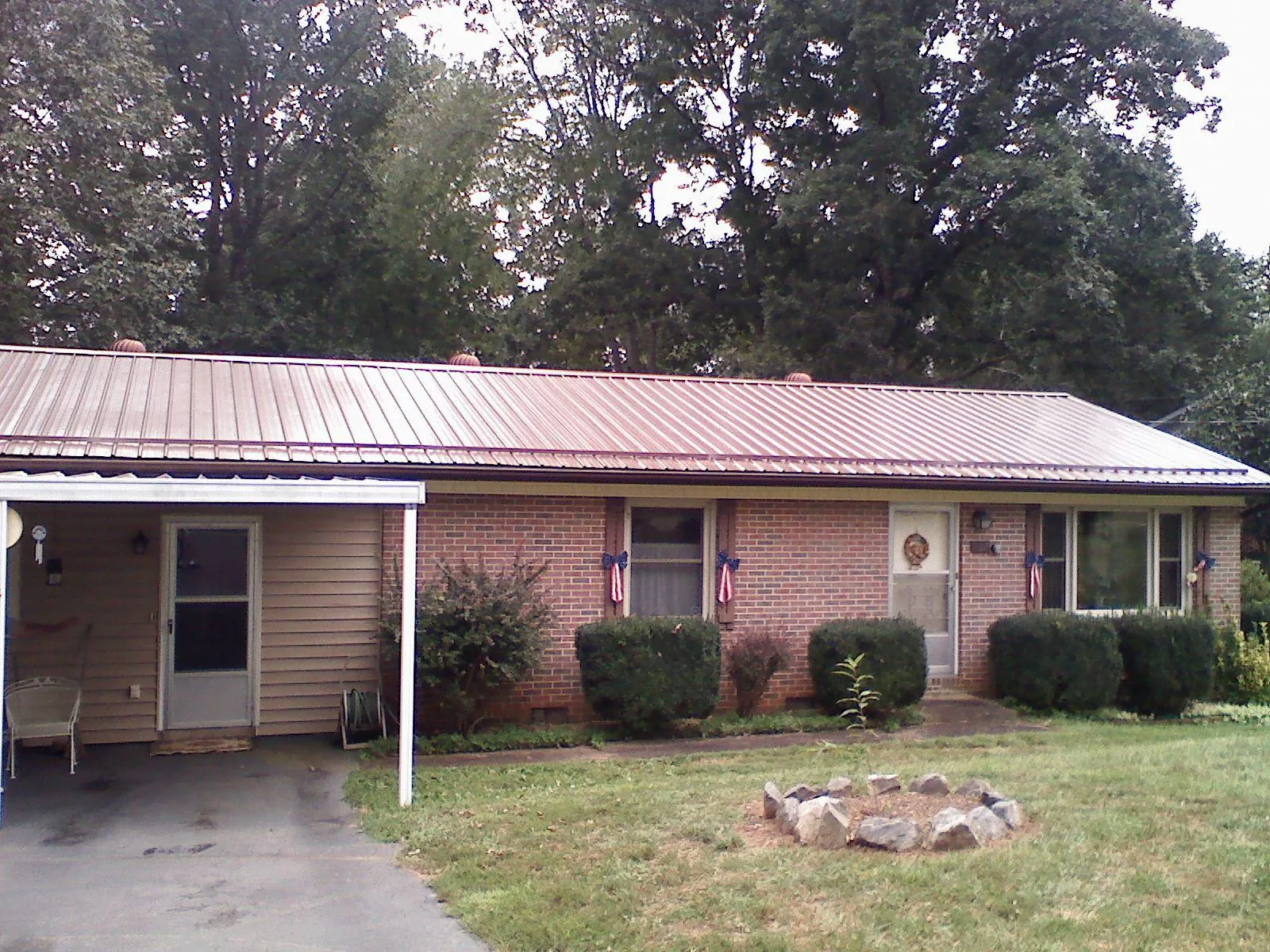 Bronze metal roof and carport on a brick ranch home — Roof Repair work by our crew in Christiana